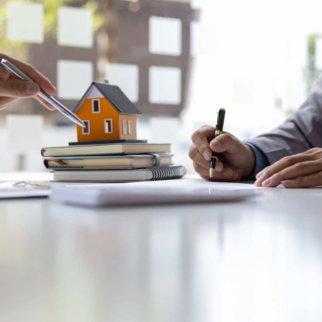 Real estate agent is discussing and explaining the terms of the home purchase contract. Businessman signing a contract agreement, mortgage, rent, lease, home insurance.